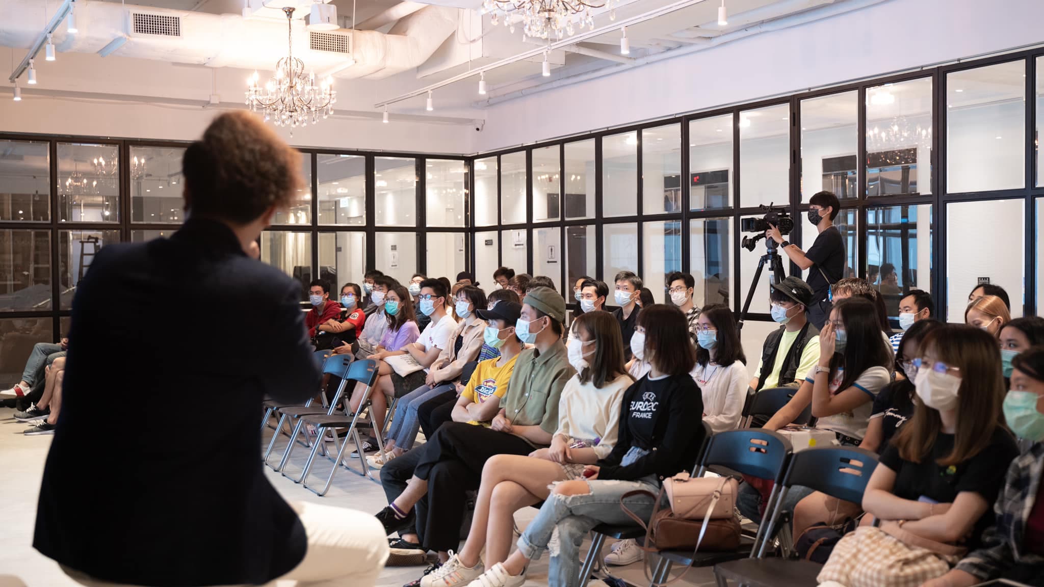 Jimmy Lee speaking to a full classroom